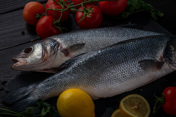 Sea bream or dorado sea fish herbs on dark slate background Top view 