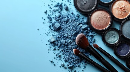 a group of makeup brushes sitting next to a pile of powdered eyeshades on top of a blue surface. - obrazy, fototapety, plakaty