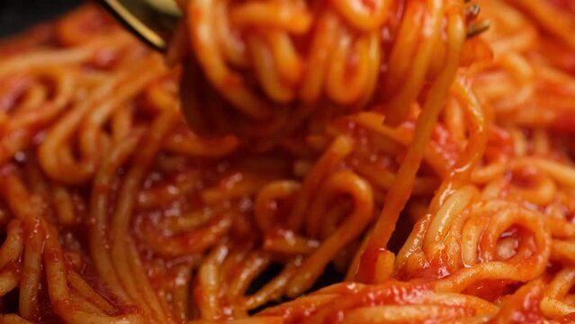 Eating spaghetti with tomato sauce