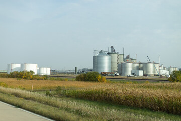 Fototapeta na wymiar Grain Storage Tanks Amidst Harvested Fields in a Rural Agricultural Setting