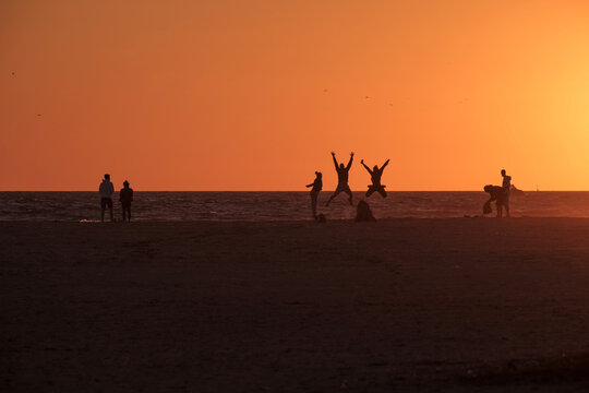 Playa de Tarifa, C&aacute;diz, atardecer en la playa, personas disfrutando de los &uacute;ltimos rayos de sol en la arena de la palya, luz dorada
