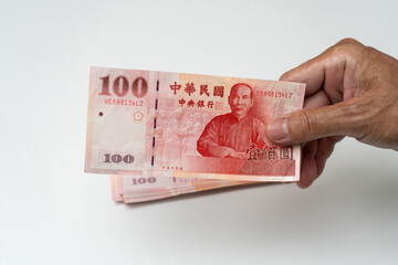 Hand holding Taiwanese dollar banknote