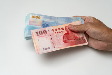 Hand holding Taiwanese dollar banknote - 778693222