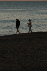 Playa de Mälaga, Andalucía, pareja paseando por la orilla al atardecer, poca luz, discutir, triesteza separación, unión y amor