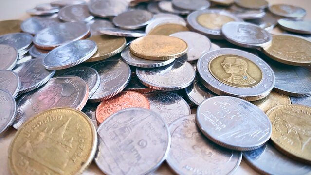 Close-up of a pile of Thai 1 baht silver coins, 2 baht silver coins, 5 baht silver coins, 10 baht silver coins, high resolution background image.