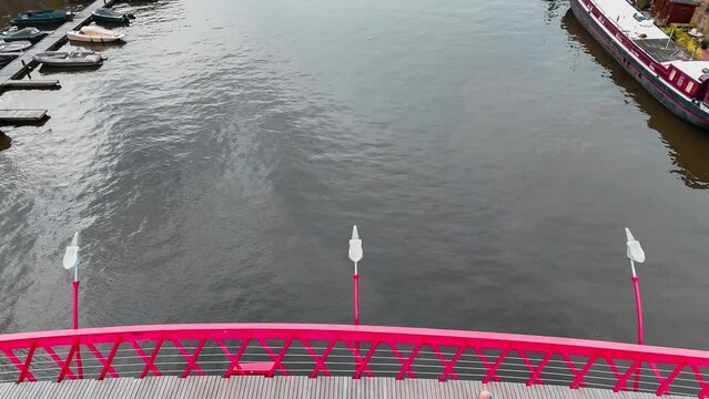 Aerial drone view of modern footbridge Python Bridge at Eastern Docklands neighborhood of Amsterdam Netherlands. High quality 4k footage