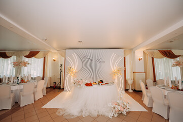 The image shows a fancy dining room with a large chandelier hanging from the ceiling and white...