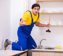 Young male contractor repairing tap at home