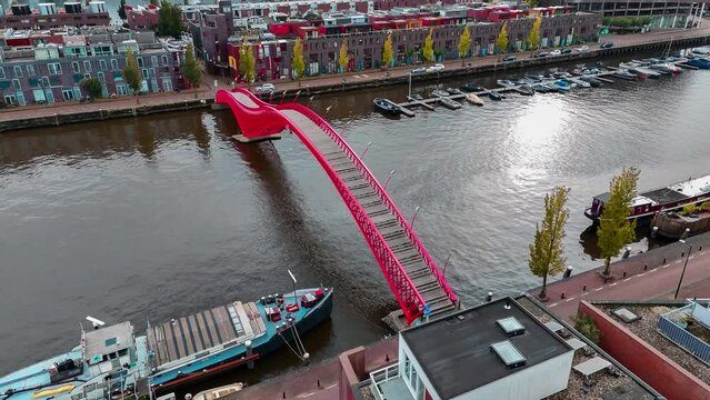 Aerial drone view of modern footbridge Python Bridge at Eastern Docklands neighborhood of Amsterdam Netherlands. High quality 4k footage