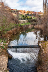 A tributary of the Douro River as it passes through the medieval town of Aranda de Duero, Spain. - obrazy, fototapety, plakaty