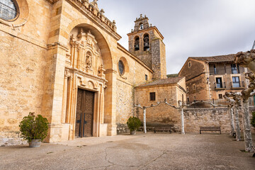 Medieval church facade with tower and bell tower in the old villages of Castilla Leon. - obrazy, fototapety, plakaty