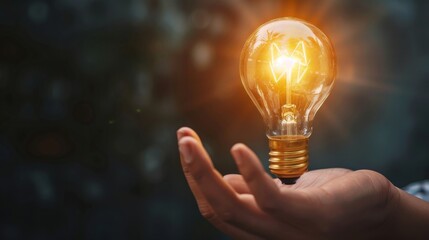 Hand holding glowing light bulb, concept for new ideas, innovation and inspiration.