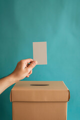 a hand throws a blank form into the ballot box. anonymous voting