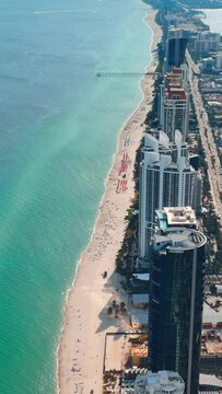 Beach on the Atlantic coast. Luxury hotel condominium apartment buildings Sunny Isles Beach. Aerial drone footage. Vertical video.