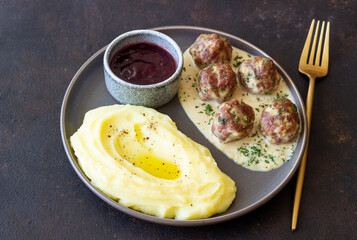 Swedish meatballs in cream sauce, potatoes and lingonberry sauce. Swedish cuisine. Recipe.