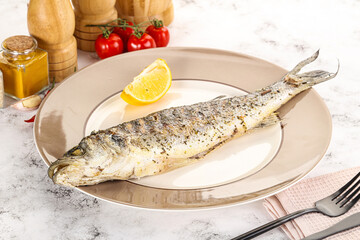 Grilled sea bass fish served lemon