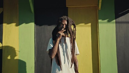 Rastafari Man in Jamaica smoking a joint while looking at the camera