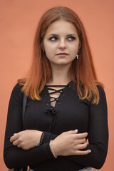 Portrait of a young beautiful red-haired girl in a summer park.