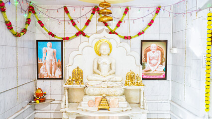 JAIN GOD IDOL picture of the deity Mahavira sculpted in white marble at a Jain temple in india mumbai
carving of buddha in sitting and meditating pose. 
mahavir jayanti. Digamber ideol arihant.