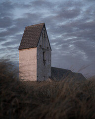 Trans Kirke, church in denmark during sunset with dramatic sky, grass in foreground