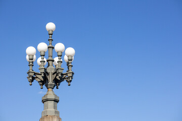 A white glass dome street lamp on a blue sky background