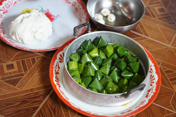 Sweet stuffed dough pyramid wrapped by banana leaf, prepared to stream. Concept,Thai traditional dessert. Prepare food for cultural celebration events.   