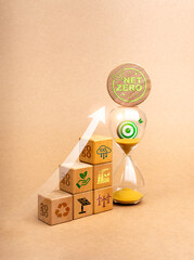 Environmental sustainability plan, Carbon emissions reduction concept. Arrow rising up to 3d target symbol on hourglass and wooden cube graph with renewable energy icon on recycle paper background.