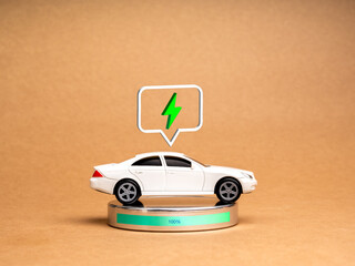 EV car, Electric energy battery charge vehicle with sustainable development concept. A White toy car with 3d electric power icon in speech bubble, recharging full energy on recycle paper background.