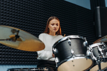 Obraz na płótnie Canvas young woman playing drum set