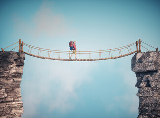 Man walking on a rope suspension bridge. Travel concept