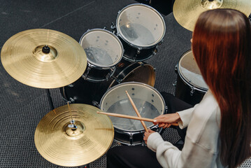 Fototapeta na wymiar young woman playing drum set