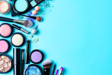 Collection of makeup products displayed on blue background.