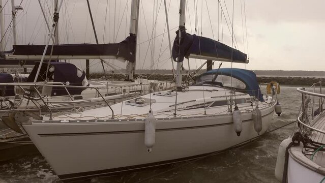 A 10m sailing yacht moored in the dock to a pontoon during a gale force storm