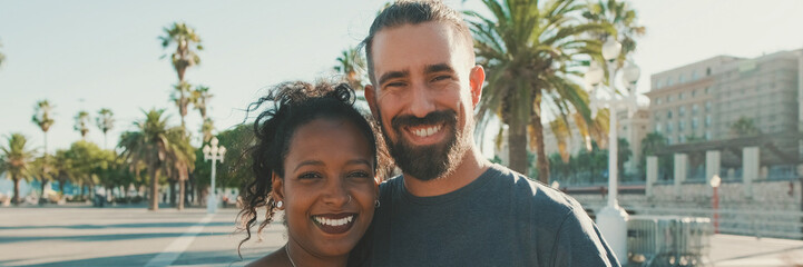 Close-up of interracial smiling couple in love, looks at camera, Panorama
