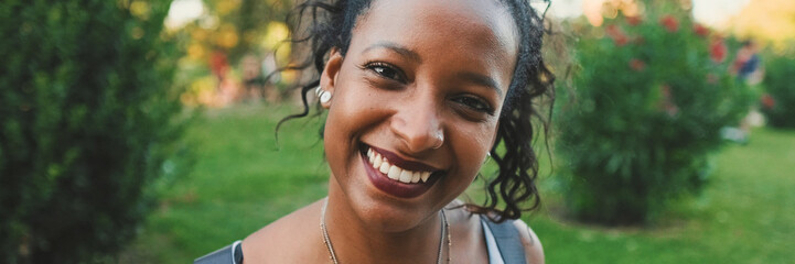 Close-up of smiling young mixed race woman looking at camera, Panorama