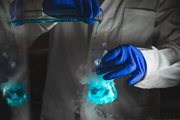 Smoky experiments with blue colour solution.  Scientist working on chemical reaction