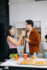 Group of Young Asian friend having, enjoy evening party together at home. Attractive young man and woman having fun, eating food, celebrate at home.