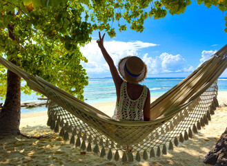 Happy traveller young woman in bikini which she is  relaxing in the hammock and freedom mood of free happiness