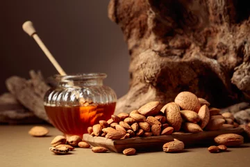 Deurstickers Almond nuts in a wooden dish and honey in a glass jar. © Igor Normann