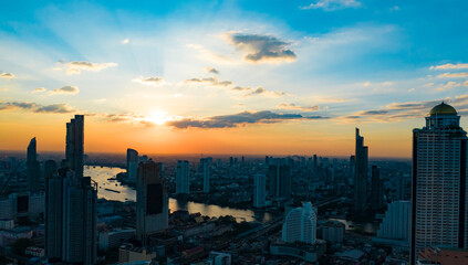 Obraz premium The sunset view with Bangkok skyline and skyscraper with the river on Sathorn Road center of business downtown.