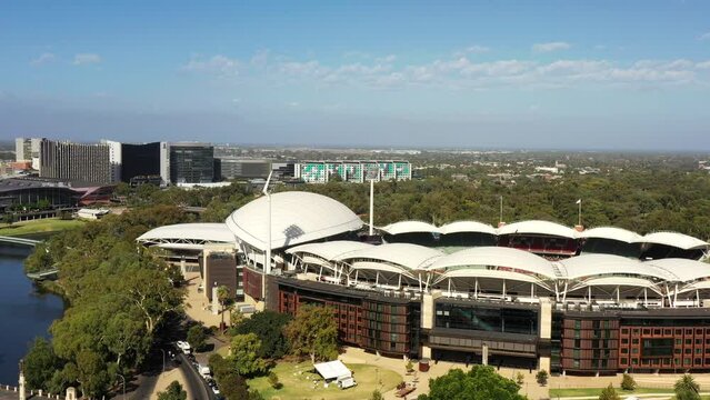 Sports arena to Adelaide city CBD skyline in aerial hovering panorama as 4k.
