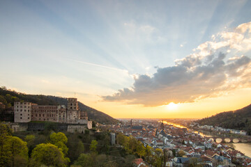 View over an old town with a castle or palace rune in the evening at sunset. This place is located...
