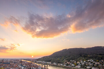 View over an old town with a castle or palace rune in the evening at sunset. This place is located...
