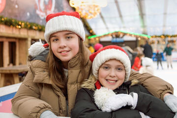 Portrait of girls 10-13 years old skating. Fun at the winter Christmas skating rink