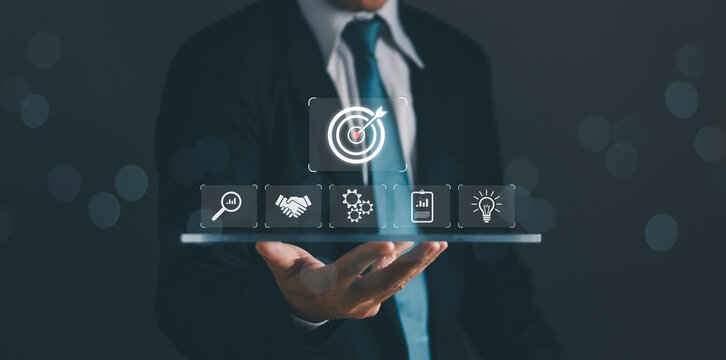 target and goal Business concept,Businessman shows dartboard and arrows for targeting objective Success or focus of the business plan