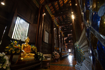 selective focus old brass Buddha statue in the dark In a temple in Thailand There is space for text.