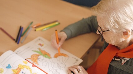 Old woman coloring a draw in a nursing home