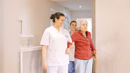 Caregivers holding arm of seniors while walking