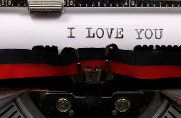 uppercase I LOVE YOU text typed in black ink on white paper with a typewriter
