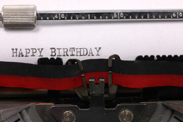 Vintage typewriter with black ink Happy Birthday message on paper
